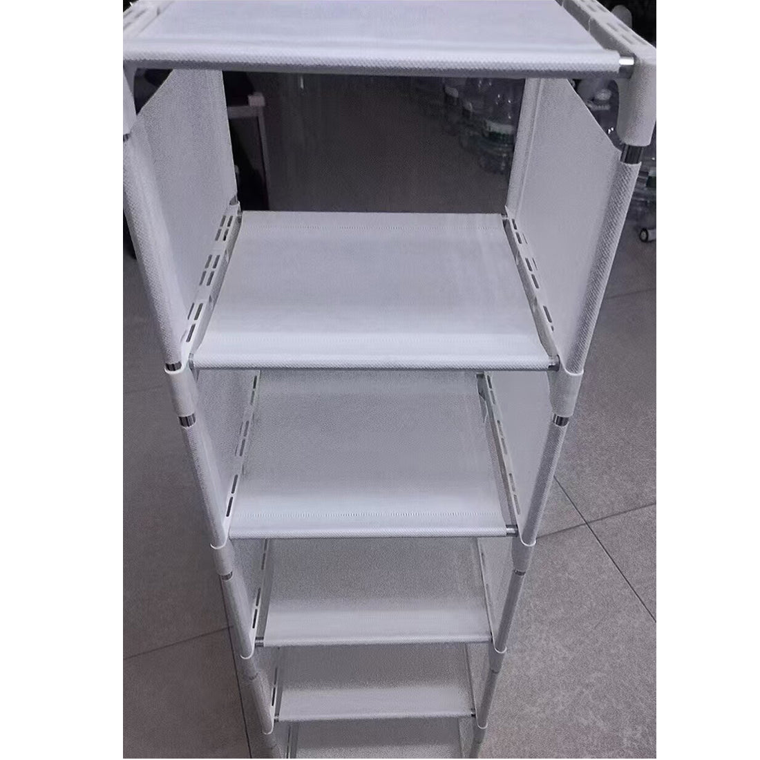 Close-up of the fabric shelves and metal frame of the shoe rack